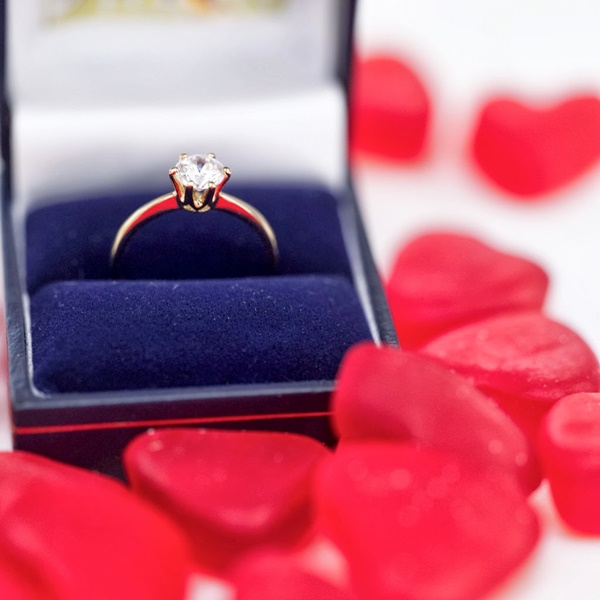 Red Heart Shaped Candies Surrounding an Engagement Ring in a Box --- Image by © Royalty-Free/Corbis