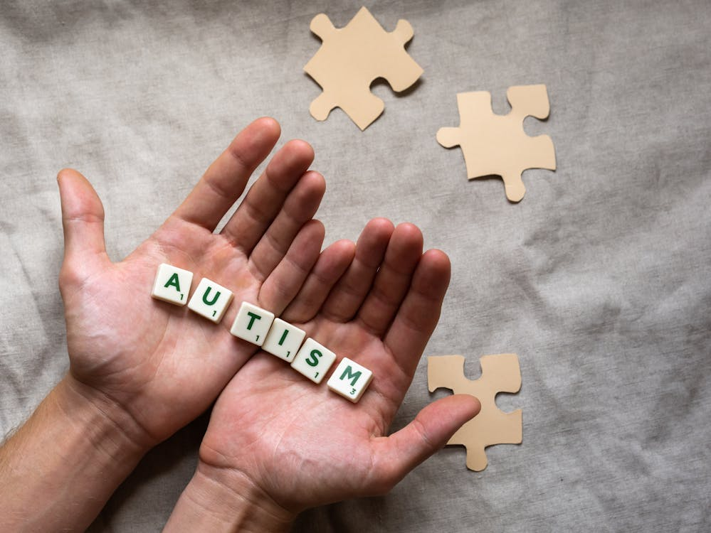 Person Holding Scrabble Tiles spelling Autism